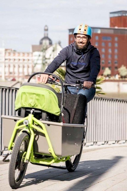 Father driving his baby thourgh traffic on a cargo bike from Radkutsche