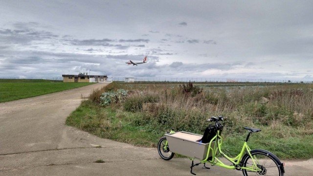 Long John cargo bike from Radkutsche GmbH on concrete tiles with a plane in the background