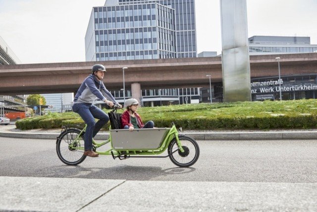 Father drives his child through trafic on a cargo bike from Radkutsche