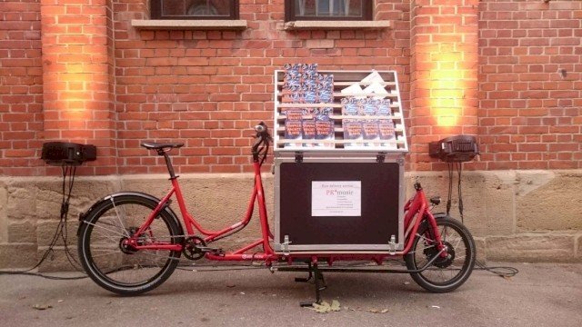 Info stand cargo bike with flyers and storage space from Radkutsche, in front of a brick wall