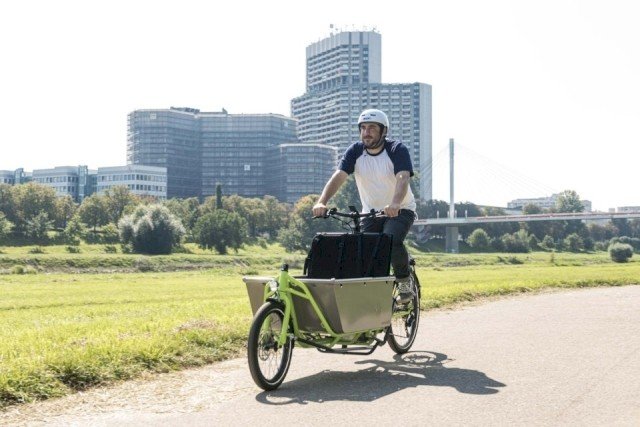Kraftmen drivers quickly to customer in town on his elektrical cargo bike from Radkutsche