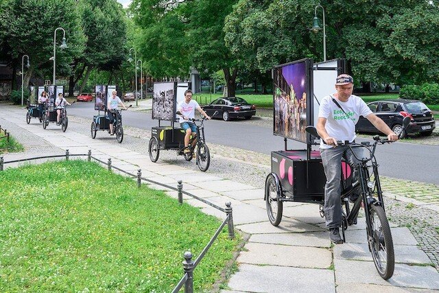 Five black three-wheeled cargo bikes from Radkutsche drive together to their next location