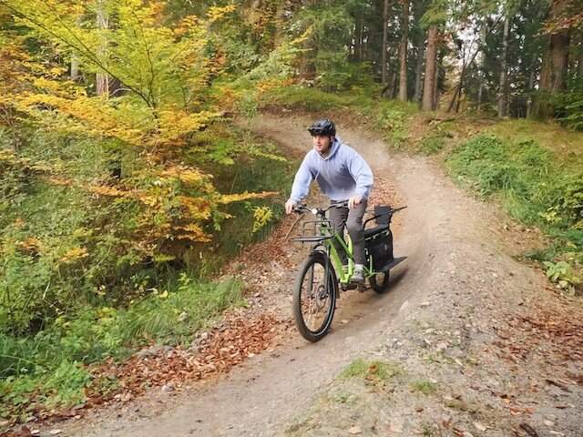 Boy glides through a corner with the long tail cargo bike from Radkutsche over in the forest