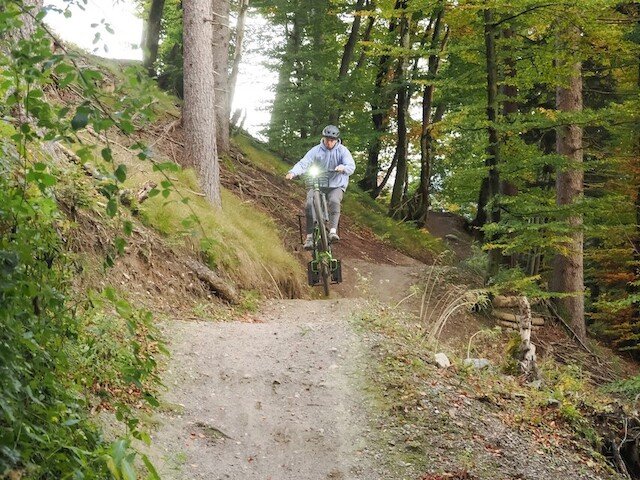 Boy jumping with the long tail cargo bike from Radkutsche over a dirt jump in the forest