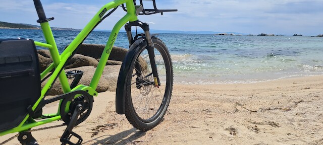 Longtail from Radkutsche called SOLID stands on the beach infront of a blue see